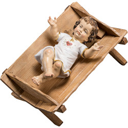 Jesuskind bekleidet mit Herz in einfacher Wiege