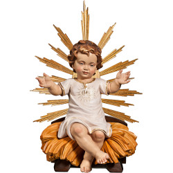 Menino Jesus vestido IHS sentado na cama com resplendor