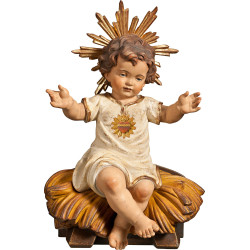 Menino Jesus vestido com Coração sentado sobre um berço